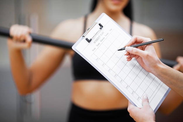 Photo fitness plan, sports trainer amounts to workout plan close-up