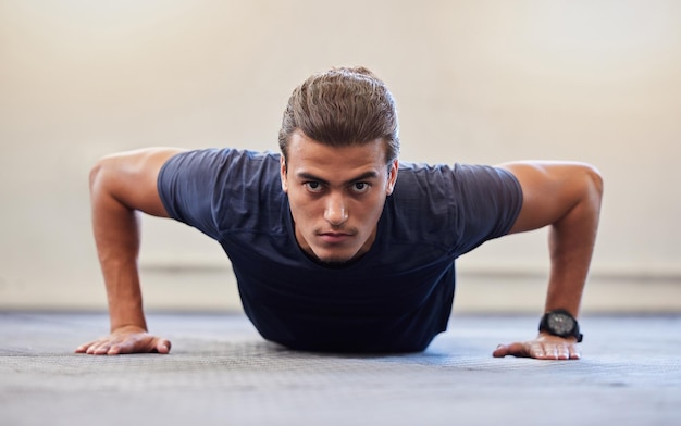 Photo fitness portrait or push up with man in gym training or exercising in a body workout for endurance healthy male strong or powerful sports athlete focused on floor exercise challenge for wellness