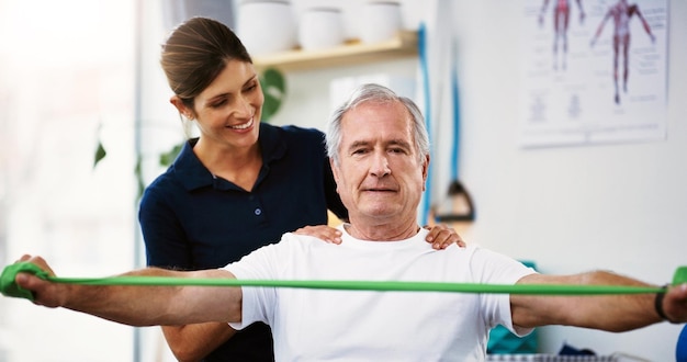 Photo fitness rehabilitation and physiotherapy with a senior man patient and female therapist at work in a clinic health wellness and consultant with a woman physio working with a male on recovery