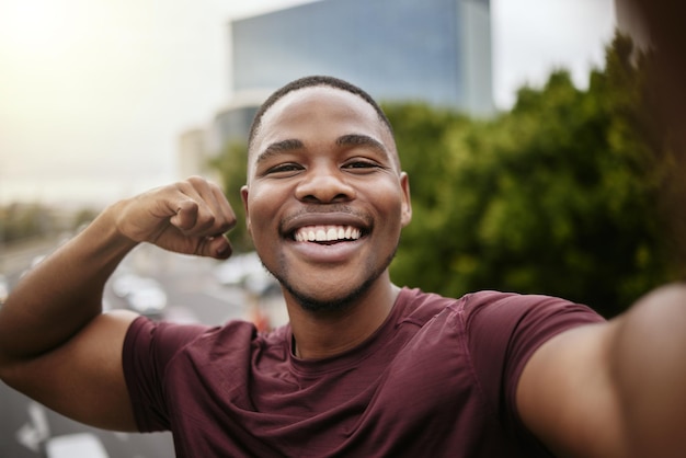 Fitness selfie en portret van een zwarte man in de stad na een training op straat op een brug Gelukkige glimlach en Afrikaanse mannelijke atleet poseren voor een foto na cardio-oefening of training in de stad
