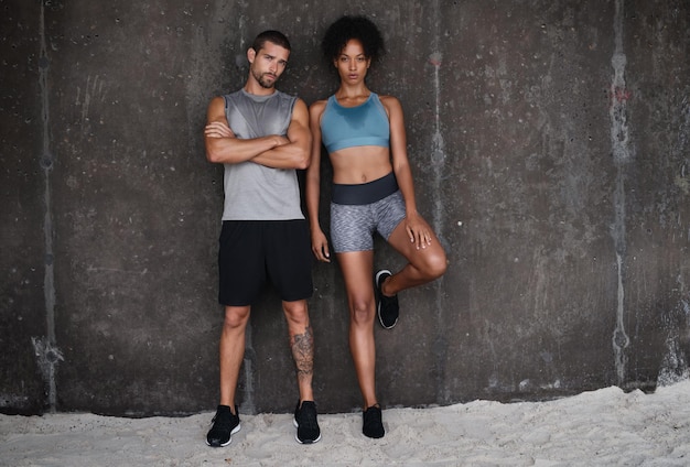 Photo fitness serious and portrait of couple at wall for workout body builder training and exercise outdoors sports athletes and man and woman after running for endurance wellness and health