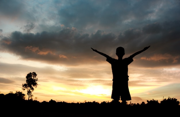 Fitness on silhouette sunrise The boy  workout wellness concept.