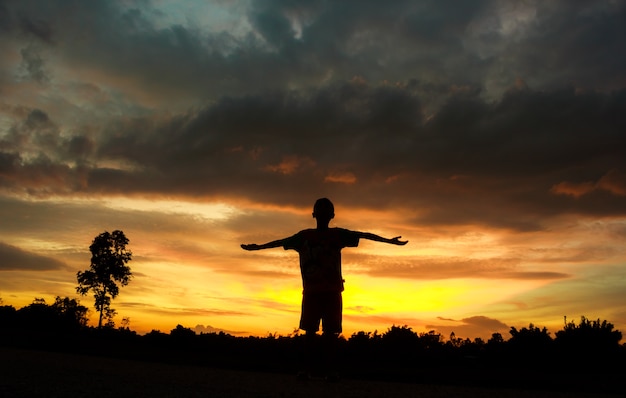 Fitness on silhouette sunrise The boy  workout wellness concept.