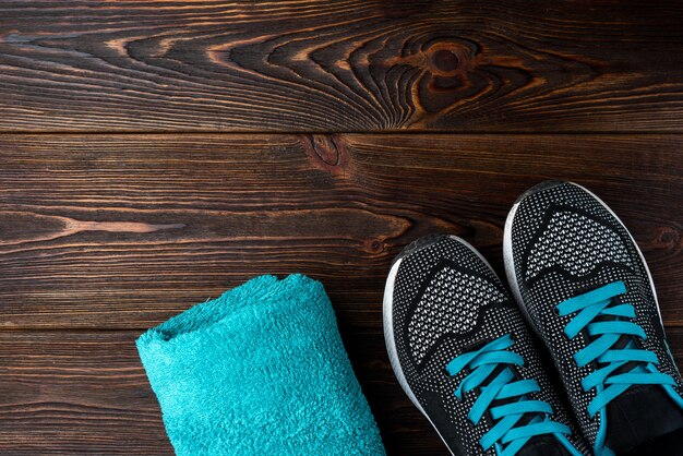 Foto fitness sneakers en handdoek op donkere houten