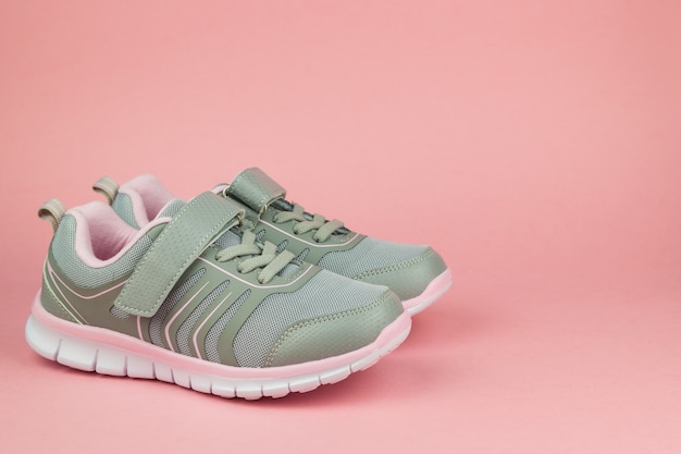 Fitness sneakers on pastel pink background. Sports shoes. Color trend.