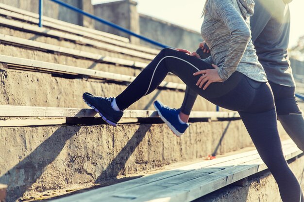 fitness, sport, beweging en lifestyle concept - close-up van paar been strekken op tribunes van stadion