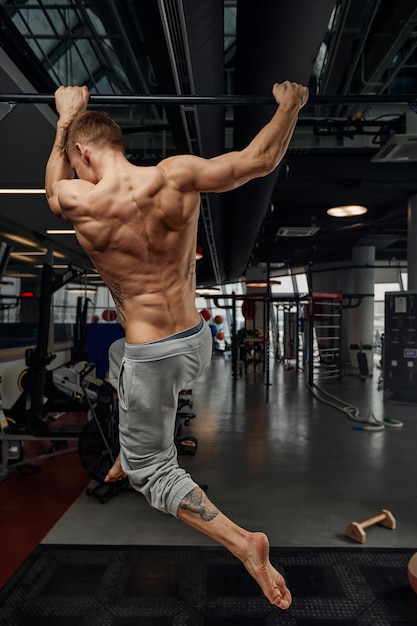 Fitness sport bodybuilding and people concept young man doing pushups on gymnastic rings in gym