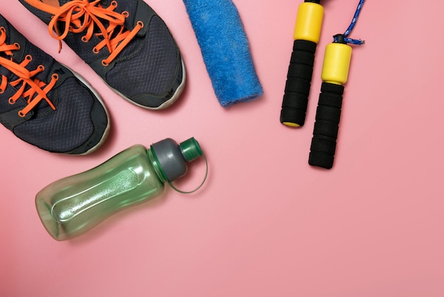 Fitness and sport concept with sneakers bottle of water and measure tape towel 