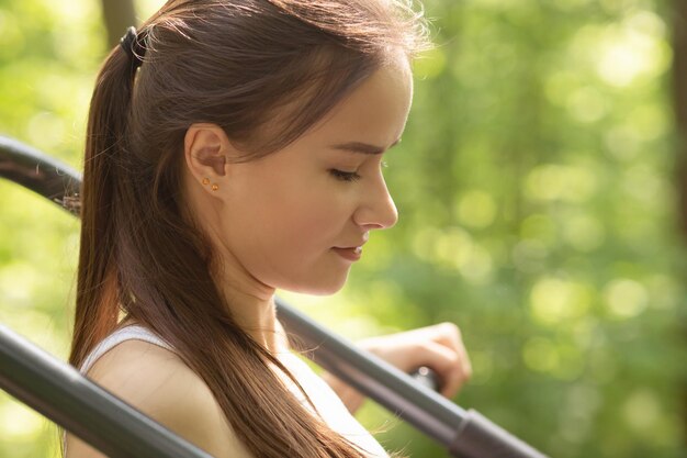 Fitness sport concept Young girl is engaged on a simulator in a park