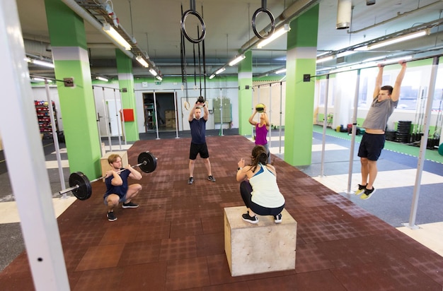 Foto fitness-, sport- en bewegingsconcept - groep mensen trainen met verschillende apparatuur in de sportschool