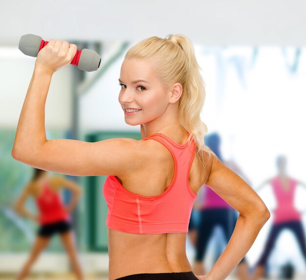 fitness, sport en dieet concept - jonge sportieve vrouw met lichte dumbbell