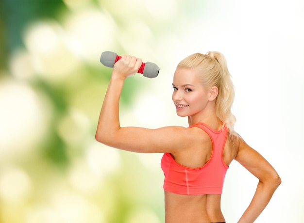 fitness, sport en dieet concept - jonge sportieve vrouw met lichte dumbbell