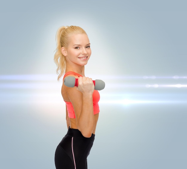 fitness, sport en dieet concept - lachende mooie sportieve vrouw met dumbbell