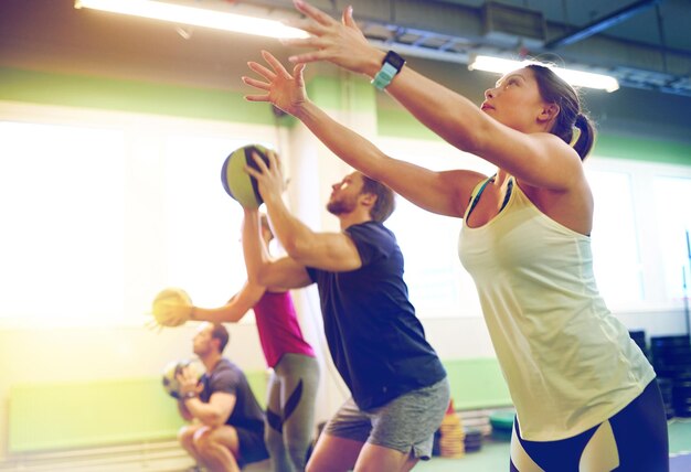 Photo fitness sport and exercising concept group of people with medicine balls training in gym