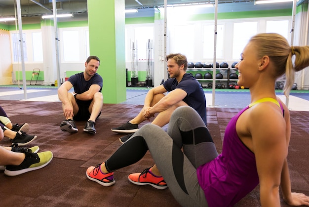 fitness, sport, exercising and healthy lifestyle concept - group of happy people resting in gym