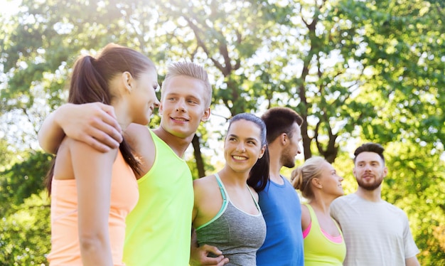 Photo fitness, sport, friendship and healthy lifestyle concept - group of happy teenage friends or sportsmen hugging and talking outdoors