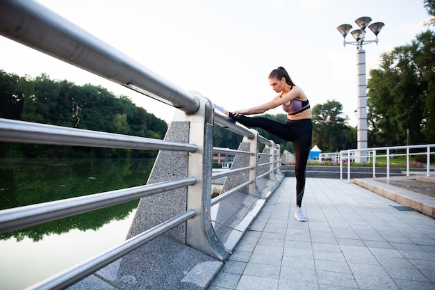 Fitness sport girl in fashion sportswear doing fitness exercise in the street, outdoor sports, urban style