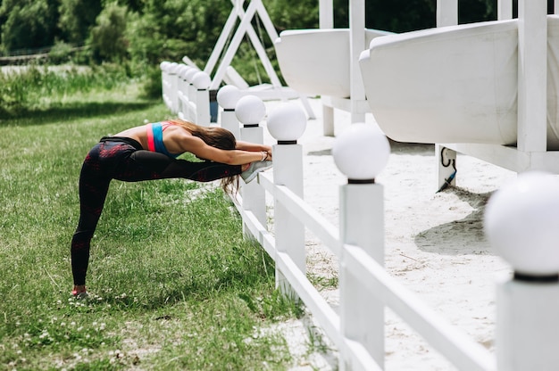 Fitness sport meisje in mode sportkleding doen yoga fitness oefening in het park