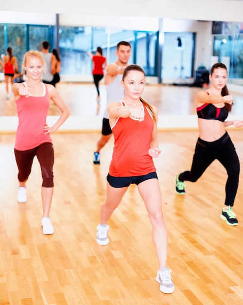 피트니스, 스포츠, 훈련, 체육관 및 라이프스타일 개념 - 체육관에서 운동하는 트레이너와 함께 집중된 사람들