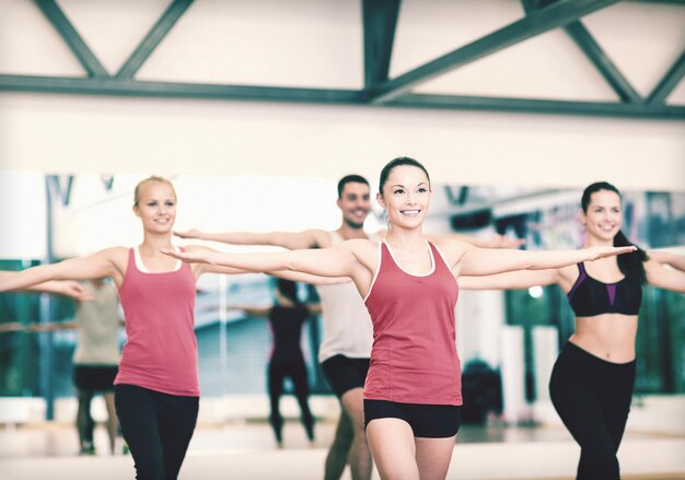 fitness, sport, training, gym and lifestyle concept - group of smiling people exercising in the gym