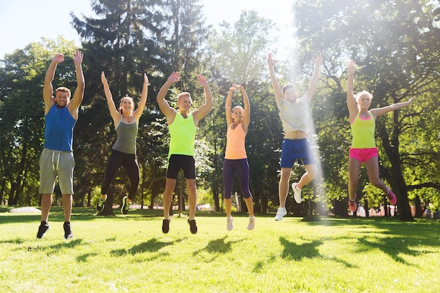 fitness, sport, vriendschap en gezond levensstijlconcept - groep gelukkige tienervrienden of sporters die hoog buiten springen