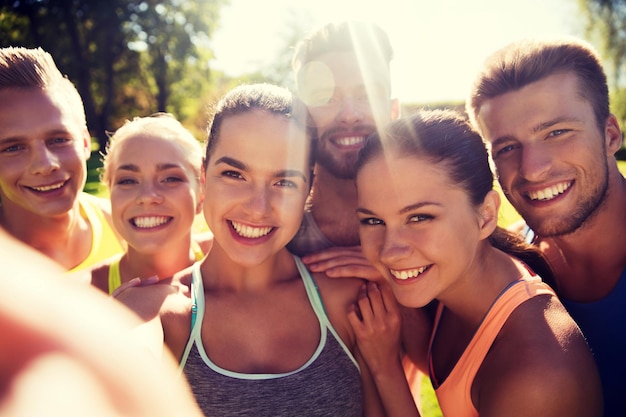 fitness, sport, vriendschap, technologie en gezond levensstijlconcept - groep gelukkige tienervrienden die selfie met smartphone buitenshuis nemen