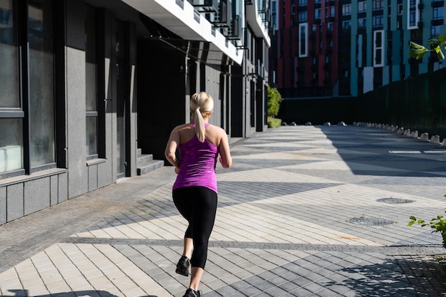 Fitness sport woman in fashion sportswear doing yoga fitness\
exercise in the street, outdoor sports, urban style