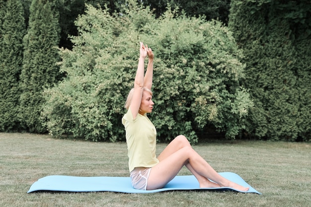 Fitness, sport, yoga in de open lucht, in het bos. Een jonge vrouw in de natuur houdt zich bezig met sporten. Gezonde levensstijl.