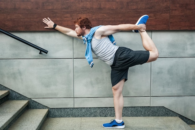 Fitness sport young adult redhead man in sportswear doing yoga fitness exercise