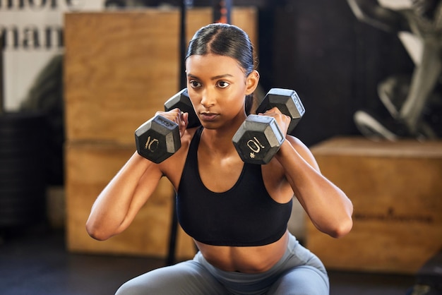 Фитнес-приседания или женщина с гантелями тренируются или тренируются для сильных рук или мышц в спортзале