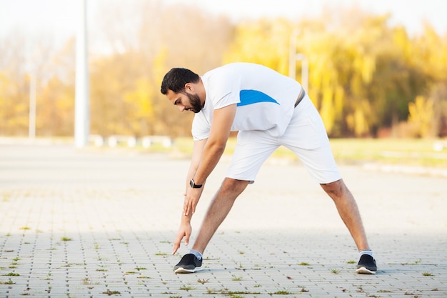 Fitness. Stretch man stretching oefening doen. Staande voorover buigende stukken benen