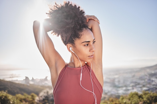 Photo fitness stretching and black woman with headphones in city for warm up to start running wellness health and girl doing workout stretch and exercise on mountain listening to music track and audio