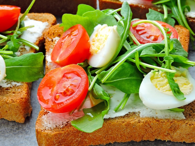 fitness toasts with arugula, cream cheese, cherry tomatoes and quail eggs