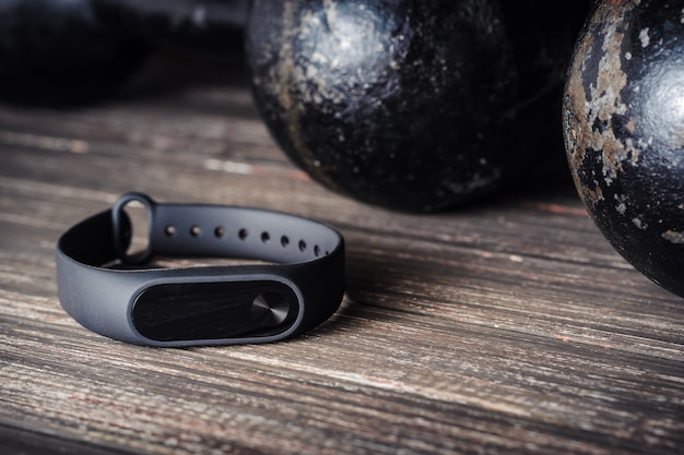 Fitness tracker en ijzeren halters op een houten achtergrond