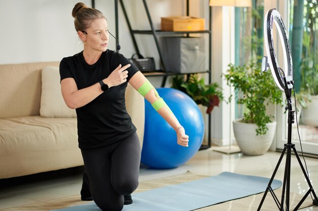 Fitness Trainer Applying Elastic Therapeutic Tape