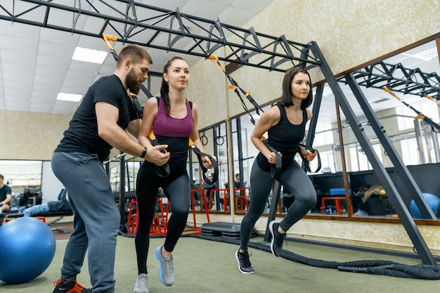 Fitness trainer coaching en het helpen van vrouwen die oefeningen doen