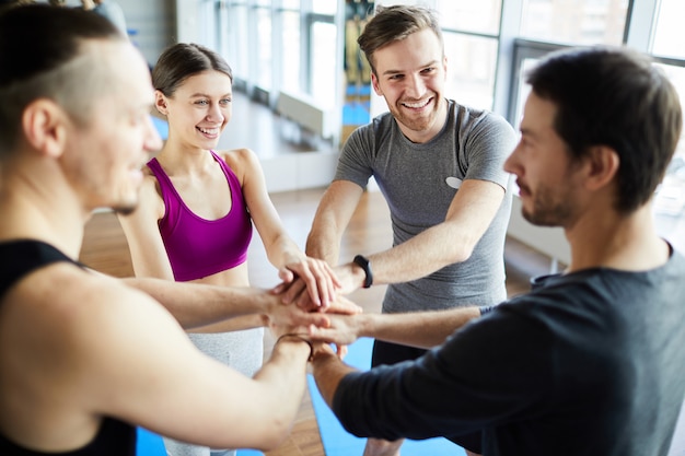 Fitness trainers stacking hands together