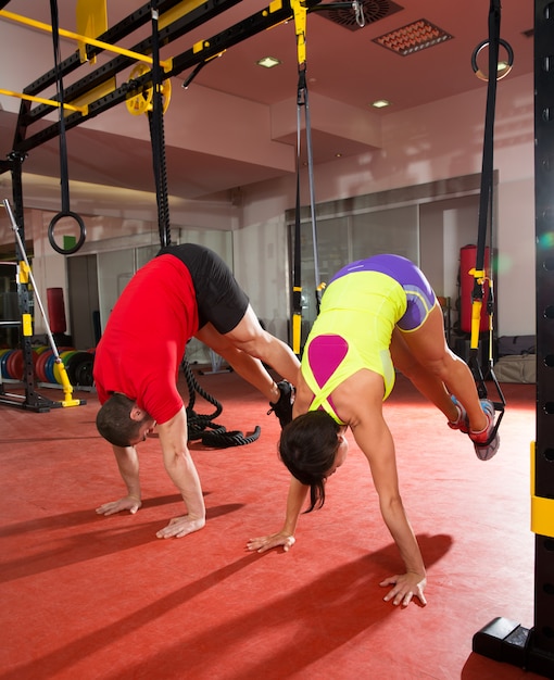 Fitness TRX training exercises at gym woman and man