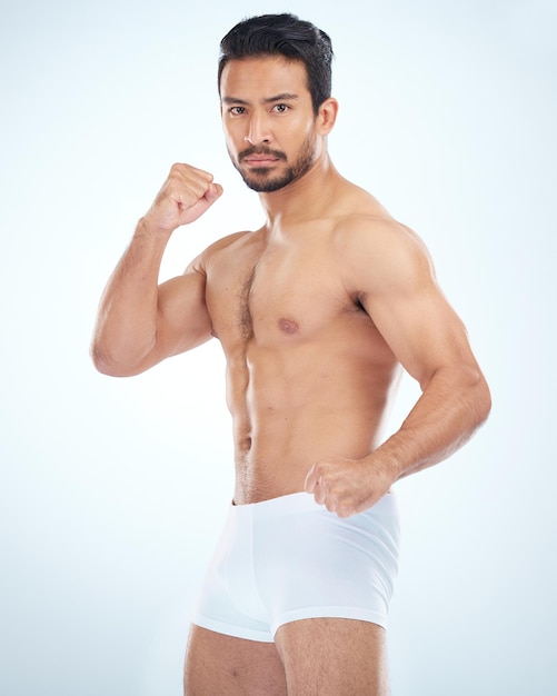 Fitness underwear and man with fist studio or martial arts with muscle wellness and strong by backdrop Model mma and shirtless with balance posture and portrait by studio background with focus