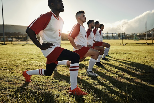 Fitness voetbal mannen en stretching met sportteam op sportveld trainingsoefening of training Atletengroep of teamwerk in diversiteitsteamwerk en samenwerking bij warming-up voor voetbalwedstrijd