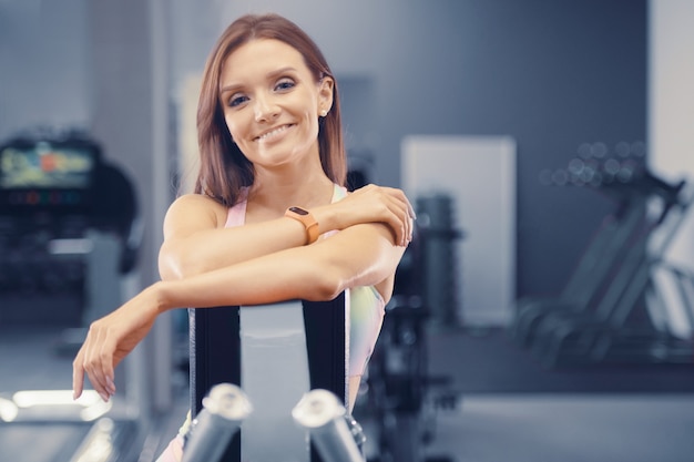 Foto fitness vrouw die spieren oppompt in de sportschool vrij kaukasisch fitnessmeisje