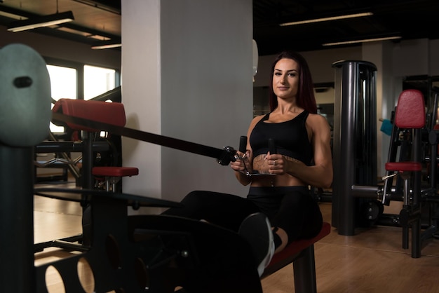 Fitness vrouw doet oefening voor terug op de machine