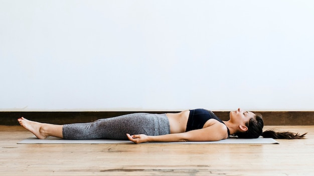 Fitness vrouw in een shavasana pose