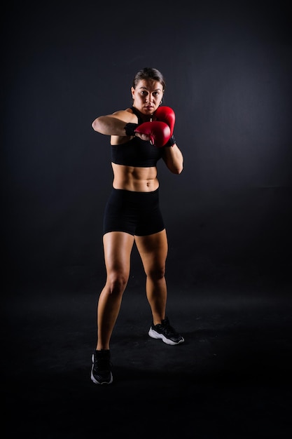 Fitness vrouw met de rode boksverbanden en handschoenen studio opname