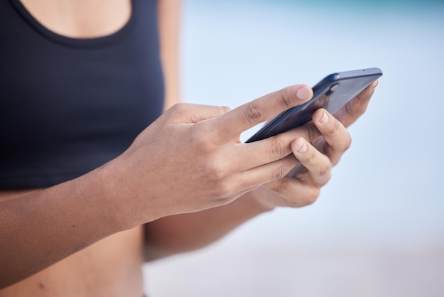 Fitness vrouw telefoon en handen typen voor communicatie sociale media of buitennetwerken Close-up van vrouwelijke persoon chatten of sms'en op mobiele smartphone-app voor online browsen of onderzoek