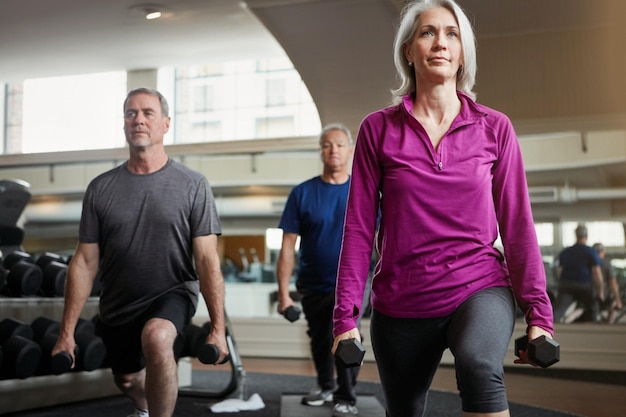 fitness weights and senior people in gym for workout training and exercise class for health retirement sports and elderly men and women with dumbbells for wellness muscle strength and mobility