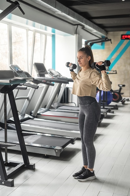 Fitness woman doing lunges exercises for leg muscles training\
training in the gym active girl sport as life