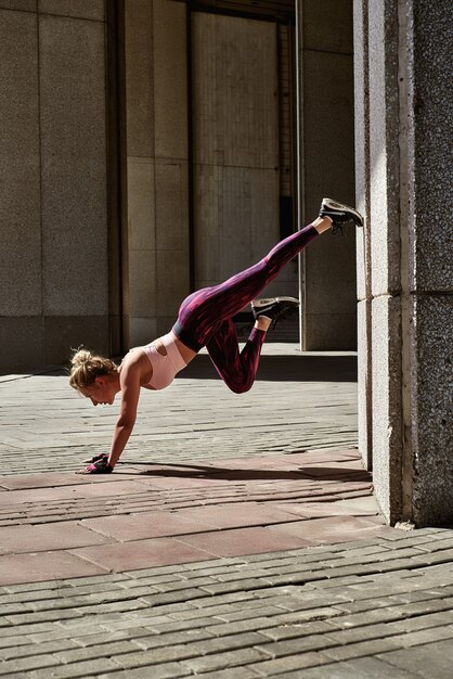 Fitness woman doing push ups Outdoor training workout summer evening side view 