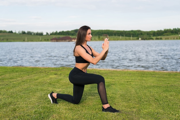 Donna di forma fisica che fa squat nel parco. allenamento all'aria aperta all'aria aperta. concetto di sport stile di vita sano.