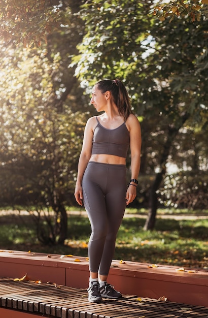 Fitness woman doing yoga exercises stretching in summer park Sport Healthy concept